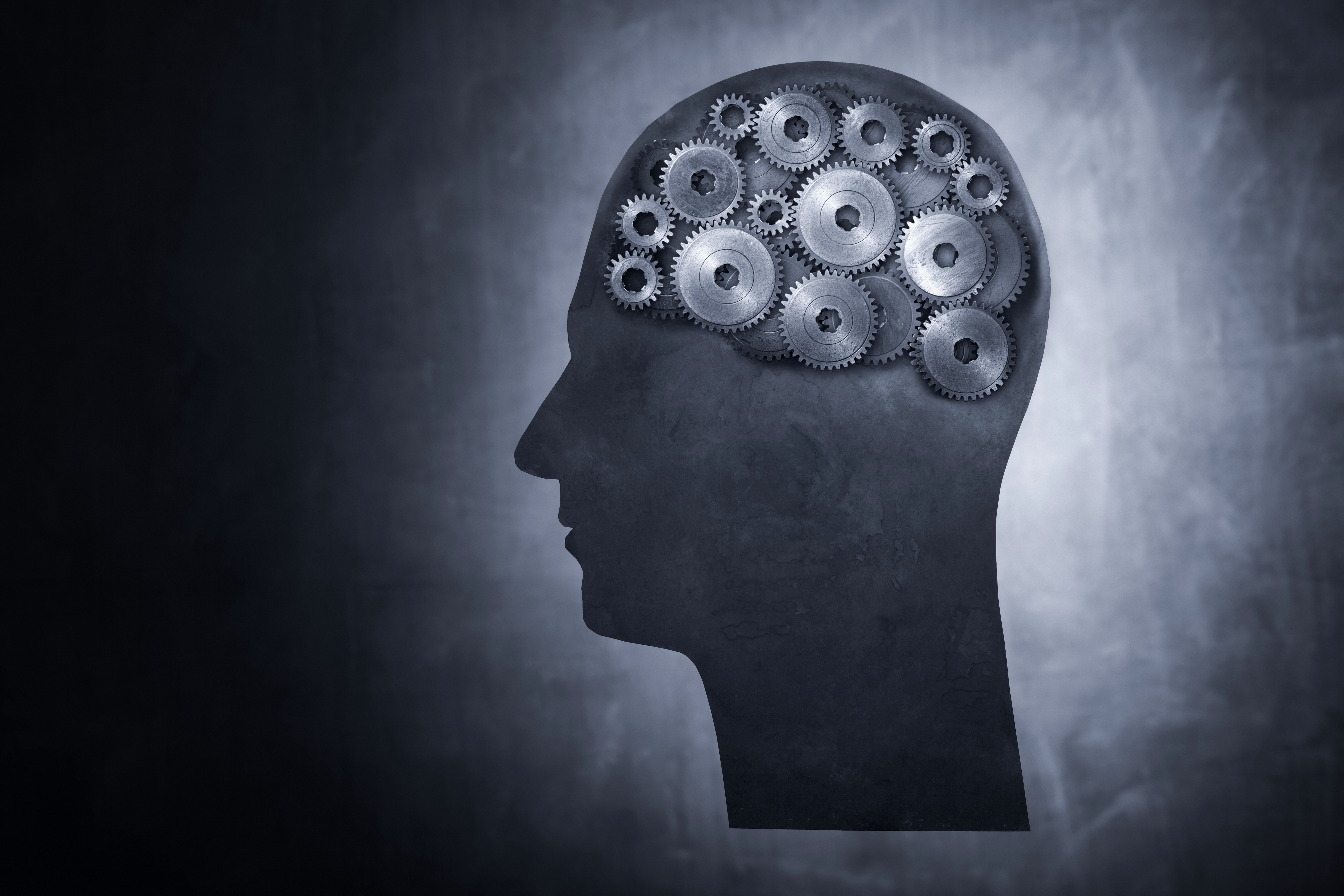 Silueta de persona formada por engranes.