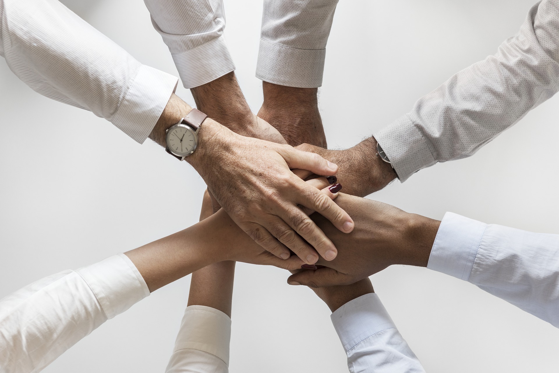 Grupo de personas juntando las manos