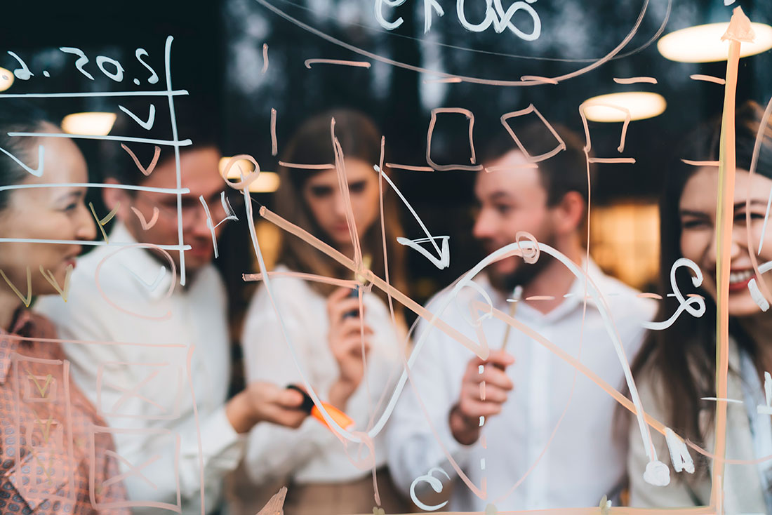 Toma de decisiones Grupo de trabajo empresarial conversando y sonriendo detrás de un vidrio con anotaciones