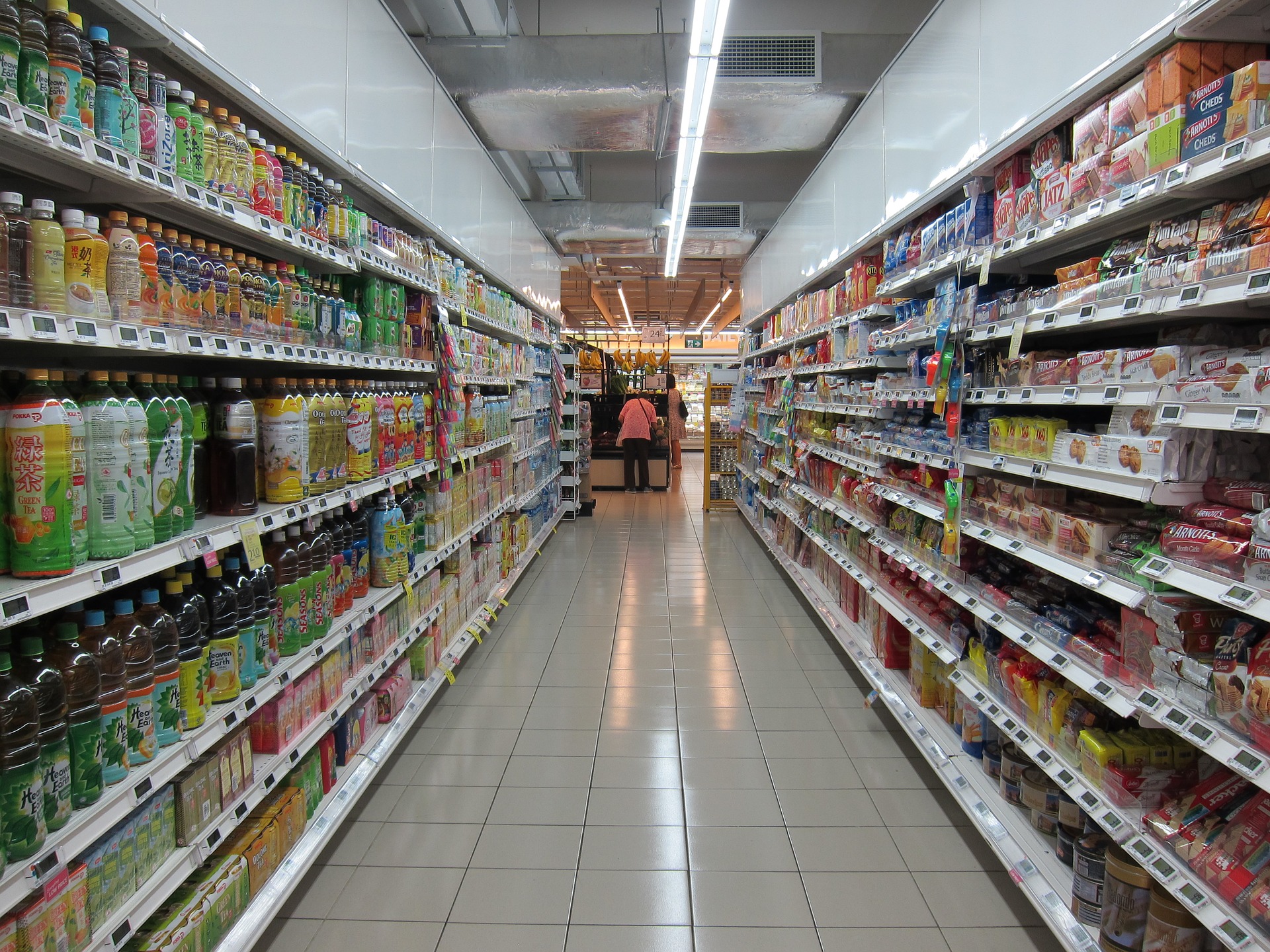 fotografía de pasillo de tienda, al fondo consumidora.