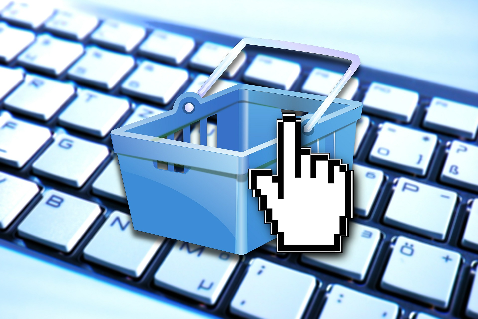 Símbolo de compra virtual, al fondo el teclado de una computadora.