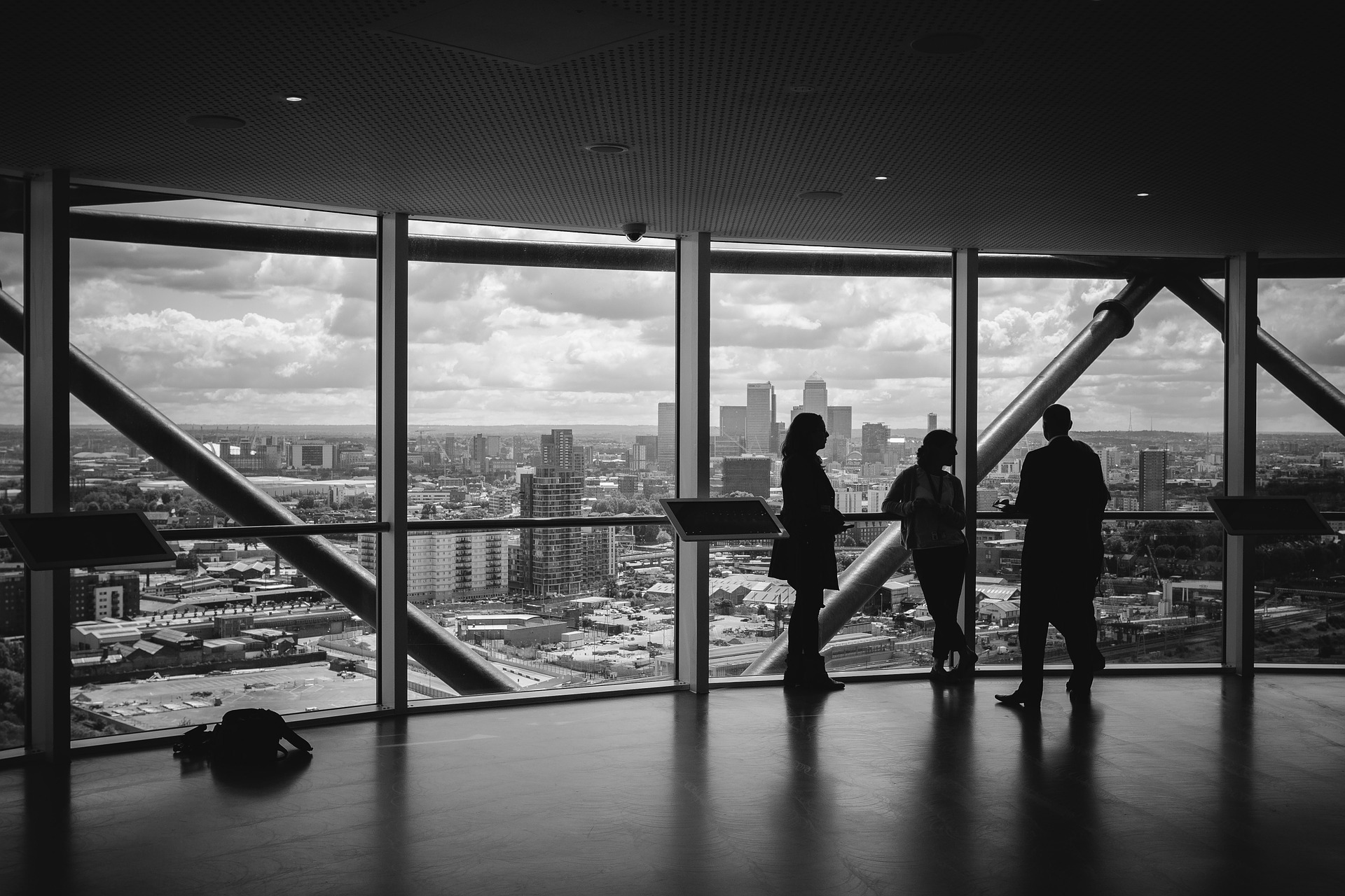 Tres personas dentro de un edificio con perspectiva a una ciudad
