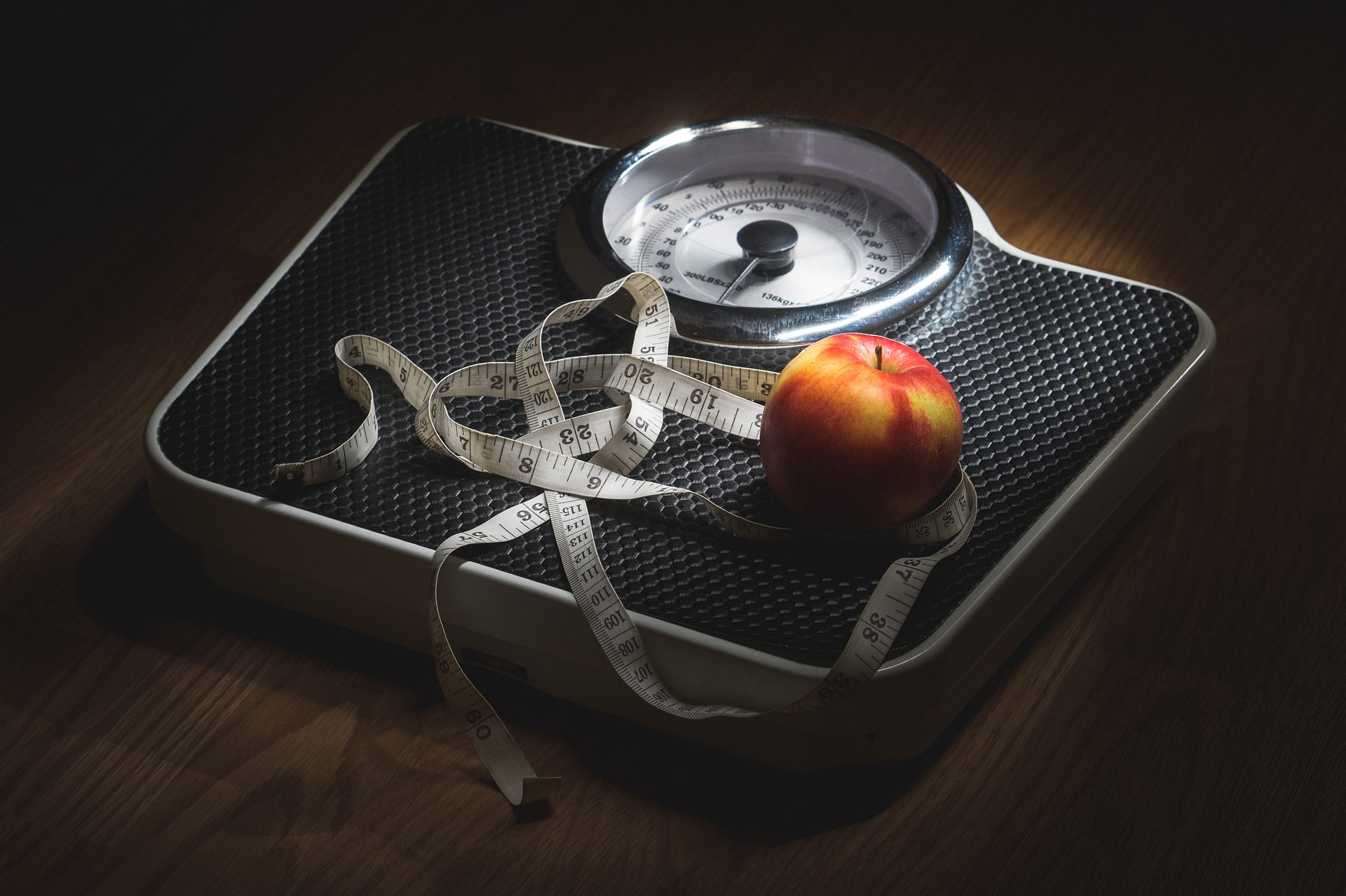 báscula, cinta métrica y manzana