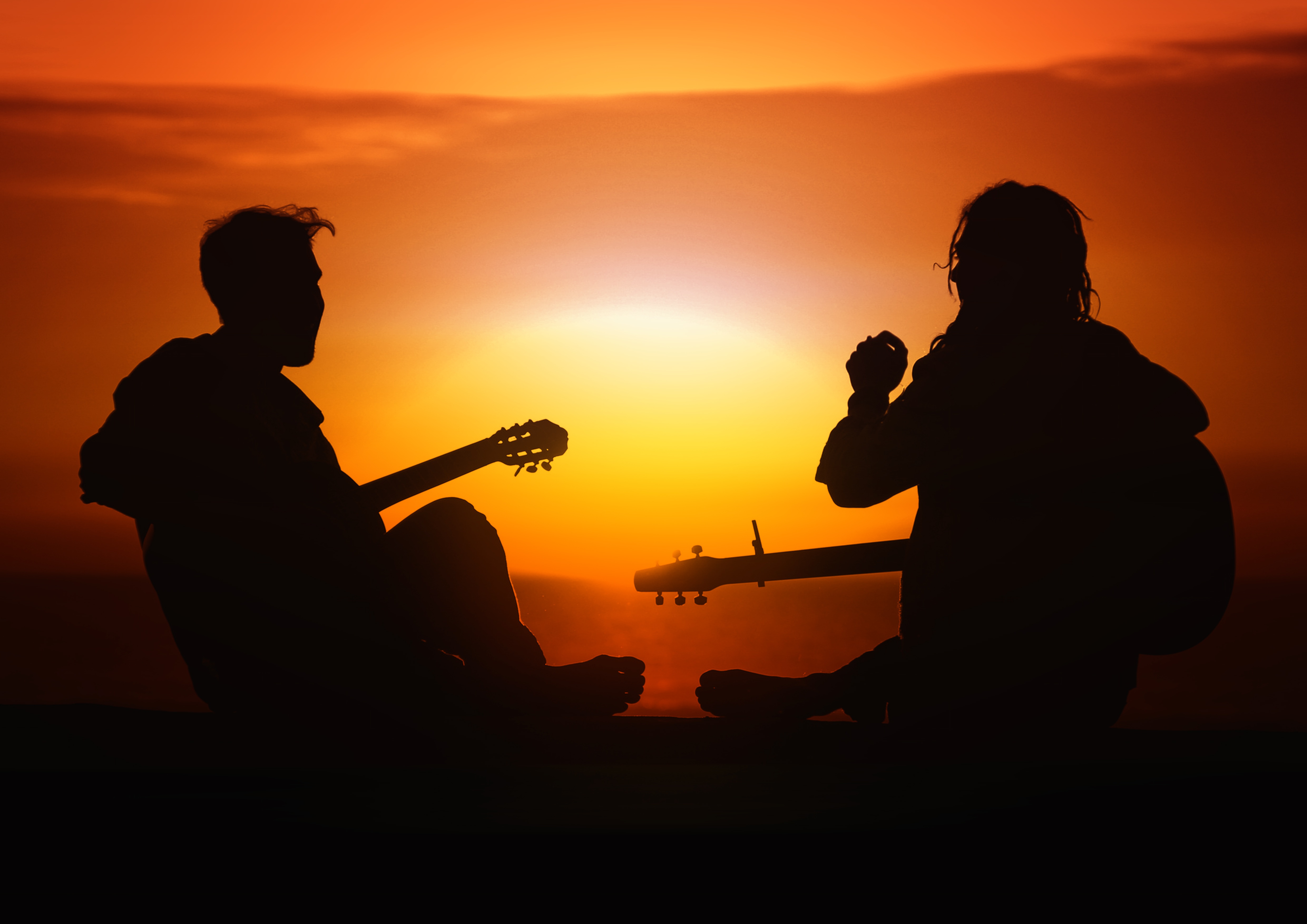 Jóvenes tocando guitarra en el atardecer.