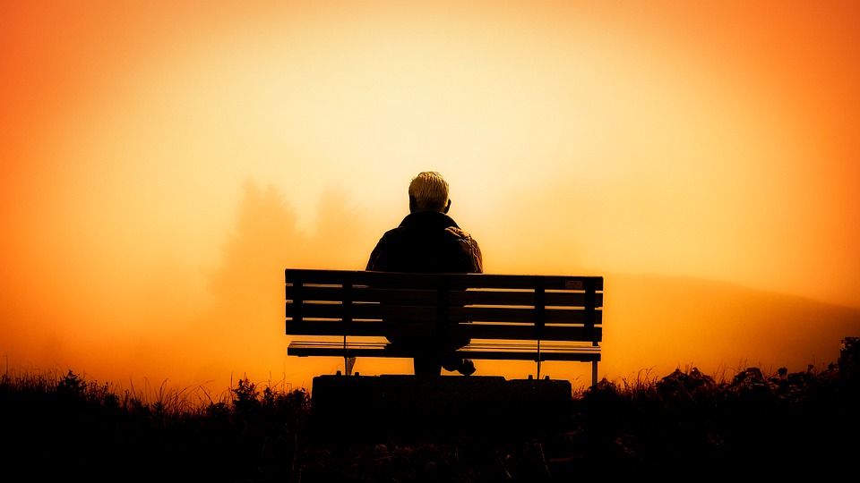 Elder man watching sunset.