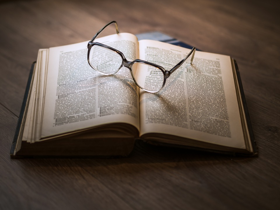 Libro abierto con anteojos sobre éste