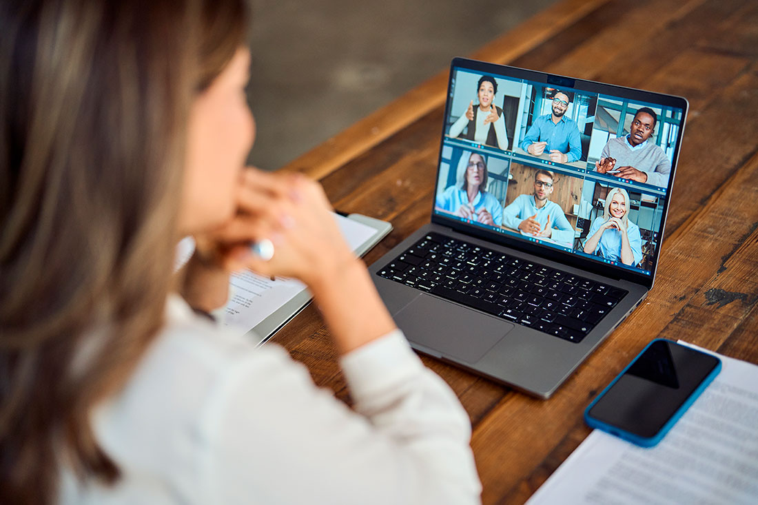 Mujer empresaria sentada frente a una laptop en una videoconferencia