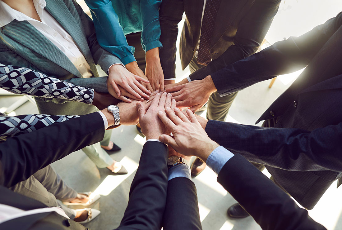 Círculo de personas empresarias uniendo las manos al centro