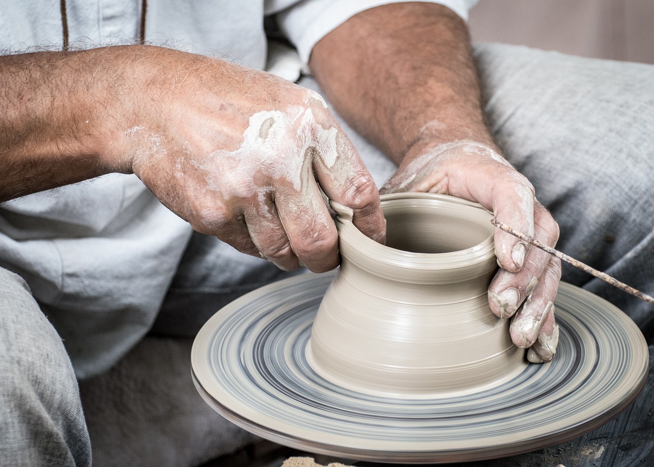 Persona creando artesanías con barro.