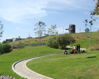 Un paisaje abierto con personas y un edificio a lo lejos