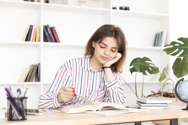 Fotografía en la que se muestra a una profesora pensando en su escritorio