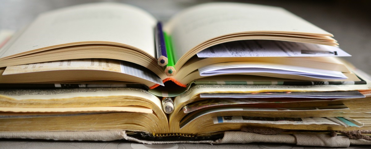 Libros apilados, con bolígrafos separando páginas Libros apilados, con bolígrafos separando páginas