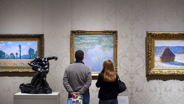 Dos visitantes observando obras impresionistas en el Museo de Boston, Estados Unidos Dos visitantes observando obras impresionistas en el Museo de Boston, Estados Unidos