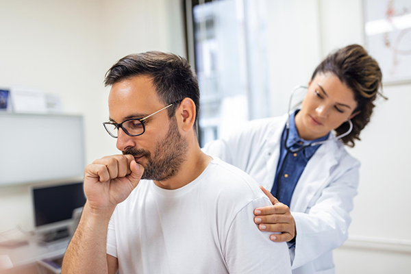 Una doctora en la clínica realiza la auscultación de los pulmones de un paciente con síntomas de coronavirus o neumonía