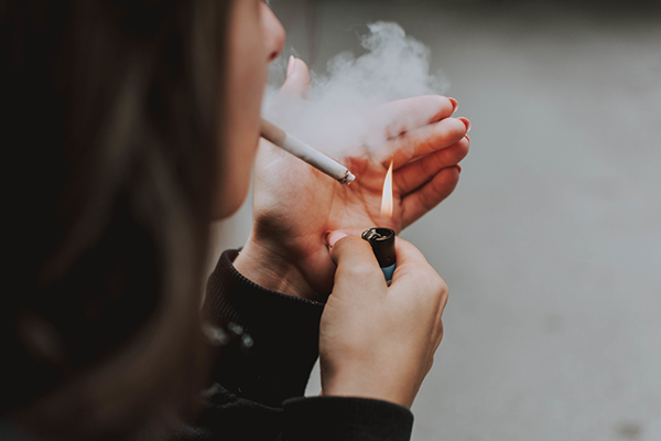 Mujer encendiendo un cigarro.
