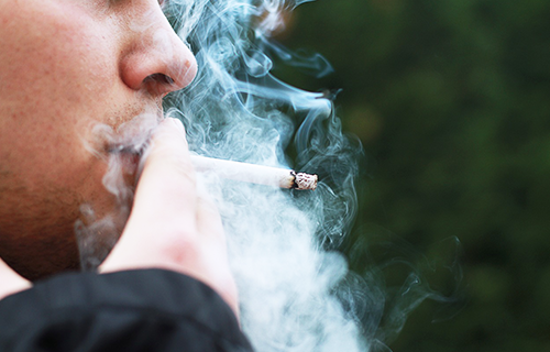 Hombre fumando un cigarrillo.