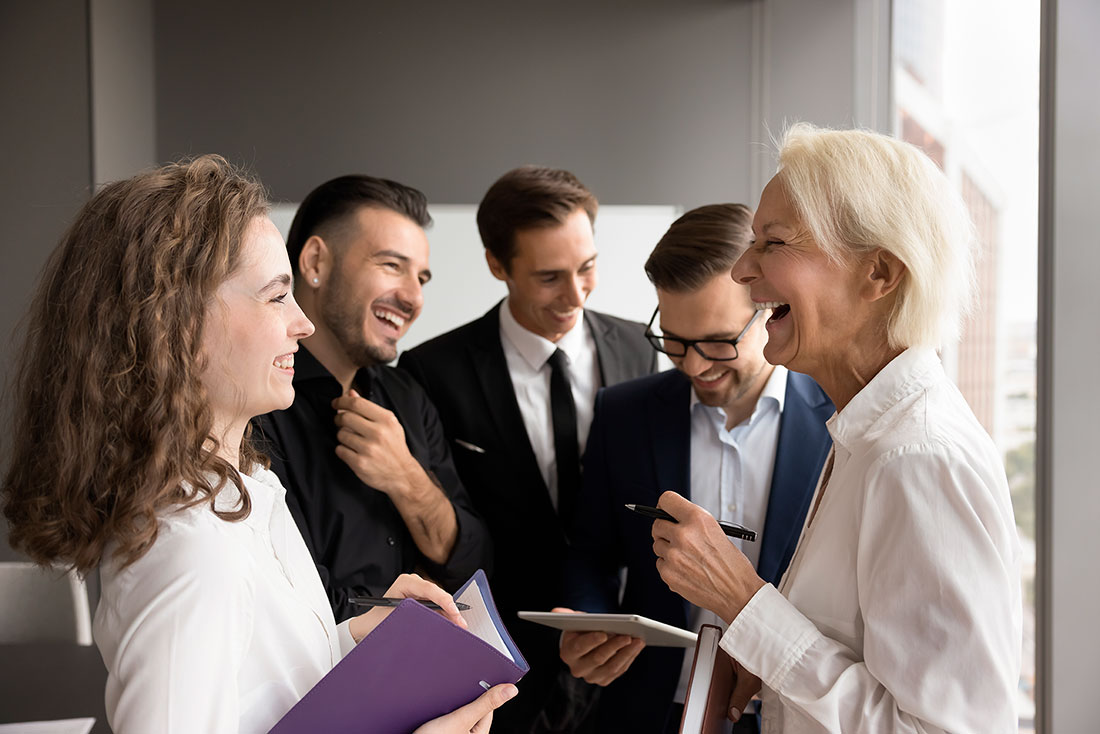 Cuatro Grupo de colegas empresariales conversando y sonriendo
