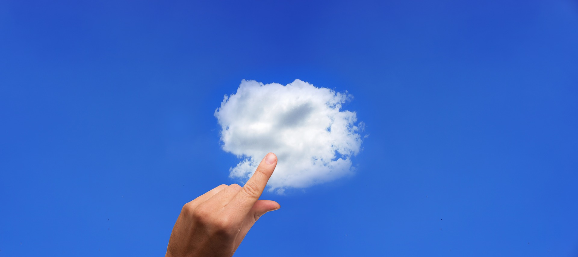 sobre un fondo de cielo azul, una mano toca una nube.