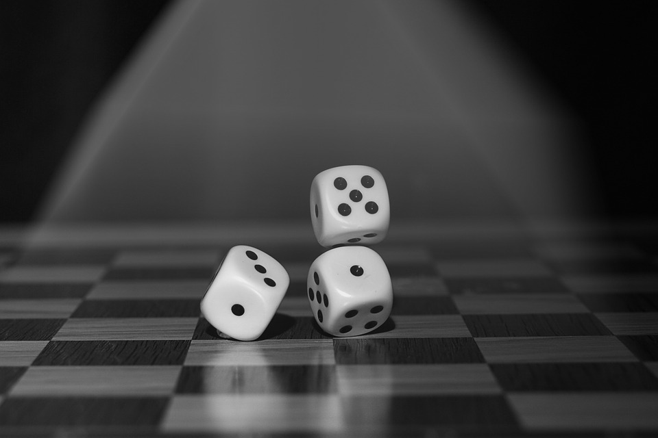 Tablero cuadriculado sobre el que se arrojan un trio de dados, cuyas caras son impares.