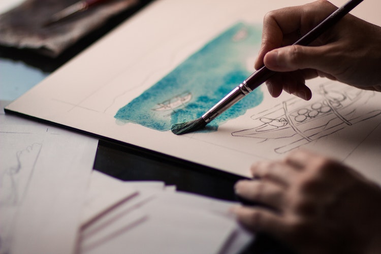 Artista aplica pigmento con pincel.
