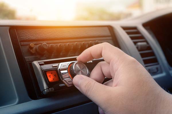 Autoestéreo Mano dando vuelta al control de volumen de un autoestéreo
