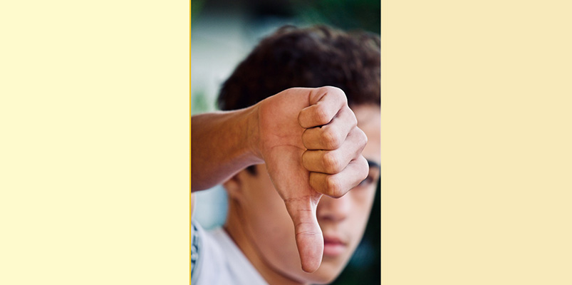 Persona con dedo pulgar apuntando hacia abajo.