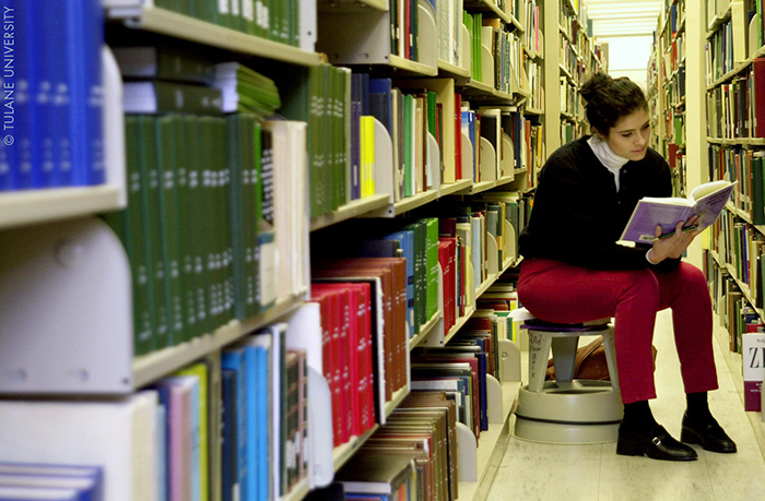 Persona leyendo en una biblioteca