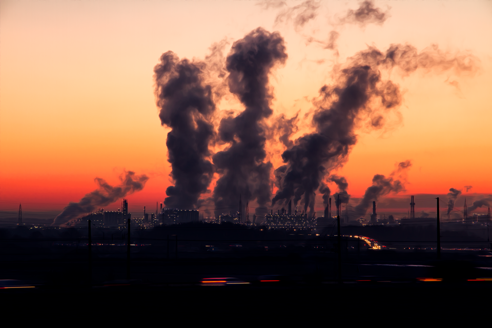 Conjunto de fábricas expulsando humo en una ciudad