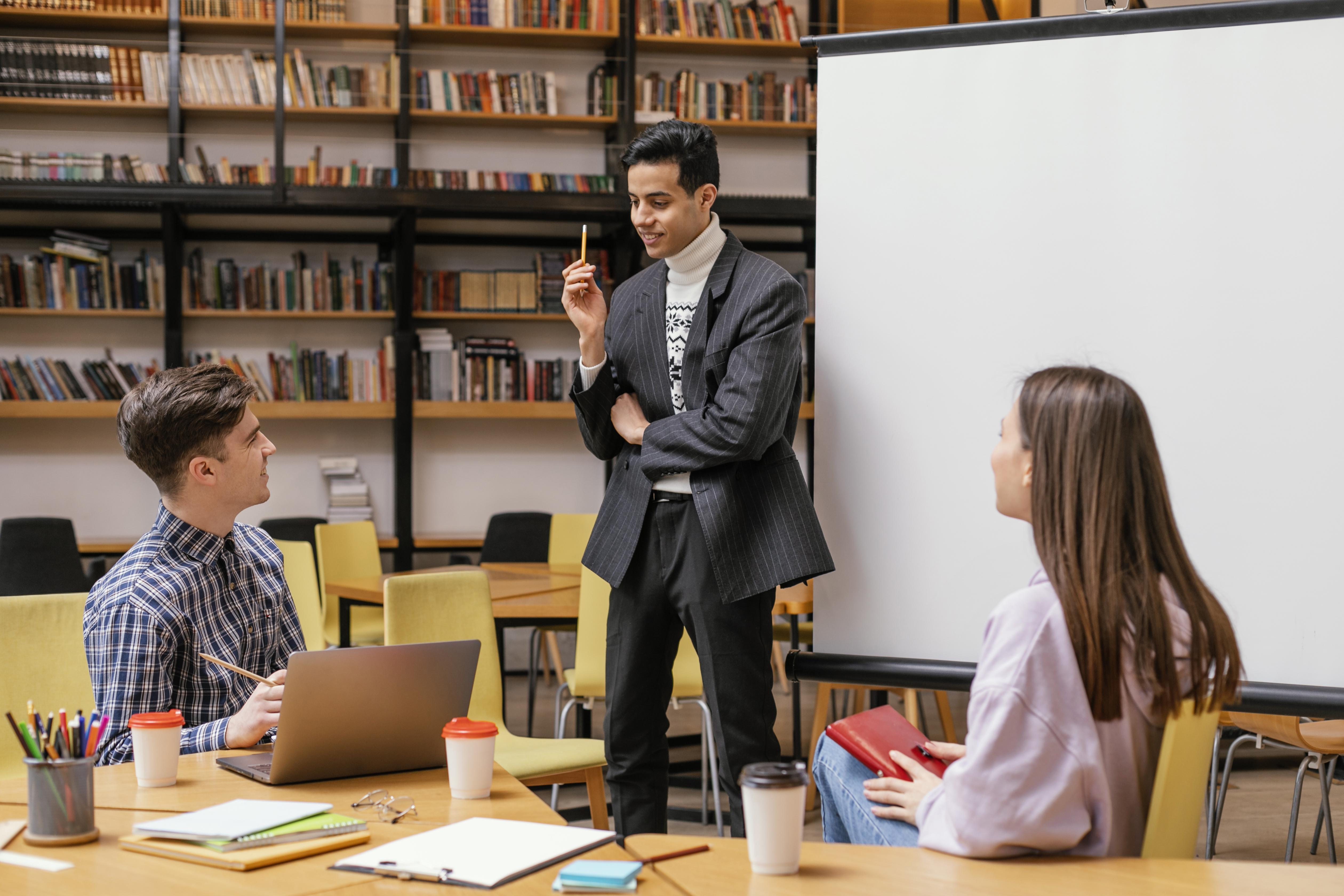 Dos personas tomando clase y una explicando