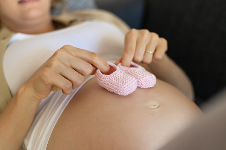 Mujer embarazada y objetos femeninos para bebé