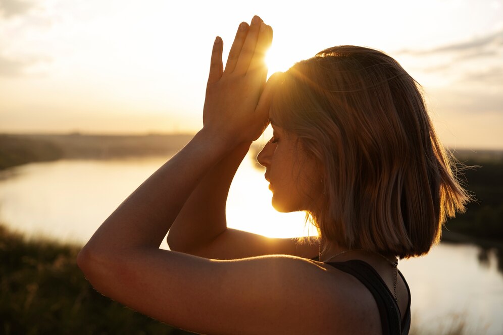 Mujer al amanecer haciendo yoga