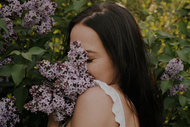 Mujer oliendo flores y feliz